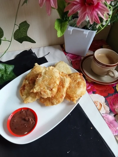 Secangkir kopi dan sepiring pisang goreng